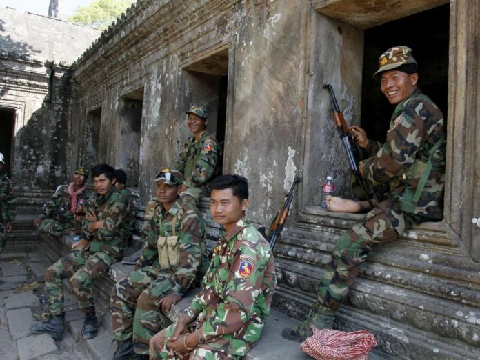 Cambodian soldiers sit at Preah Vihear temple after a brief clash with Thai troops